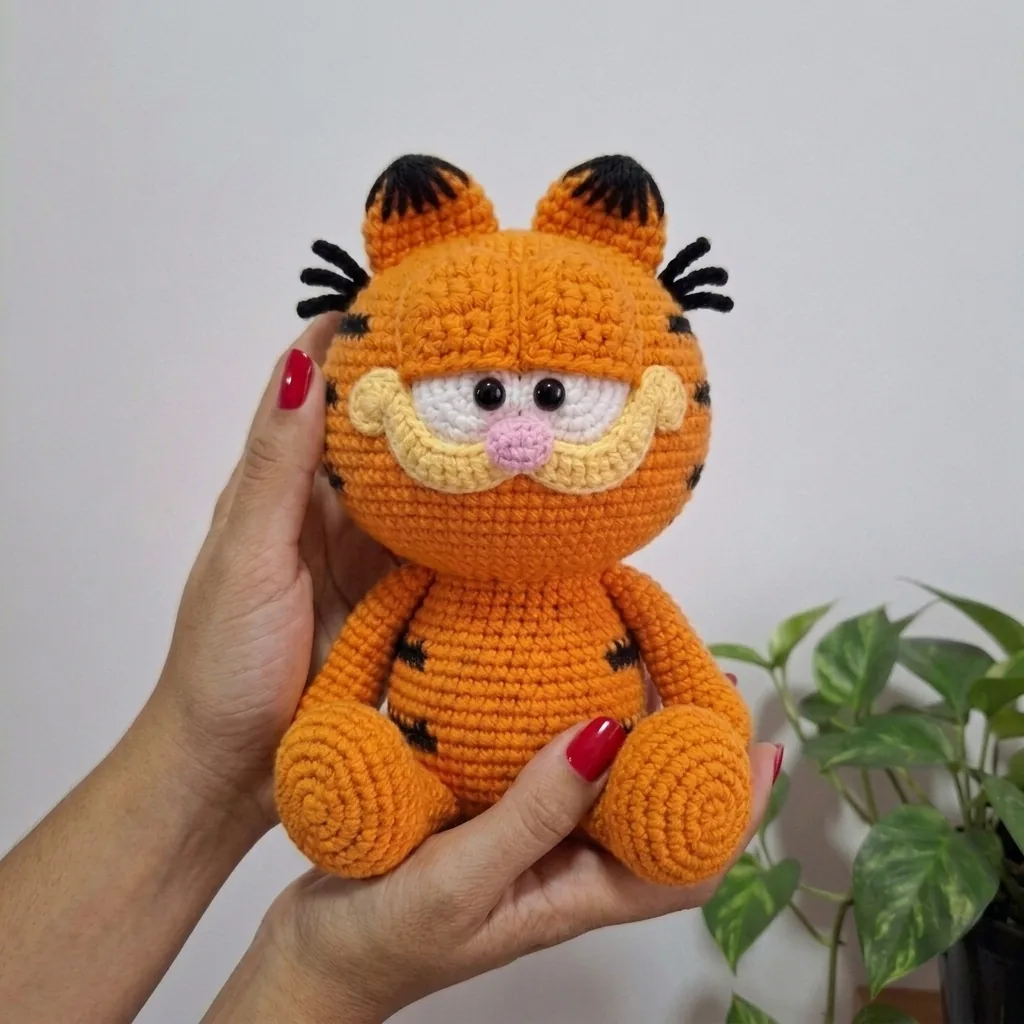 Finished Garfield amigurumi held in hands